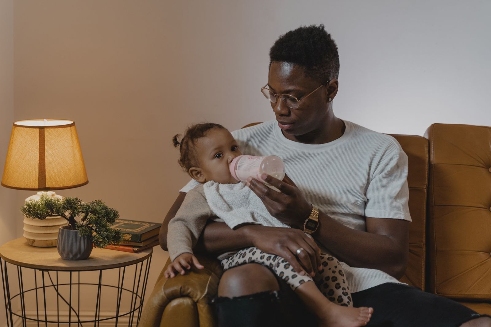 Ein Elternteil füttert ein Baby ruhig mit der Flasche auf dem Arm