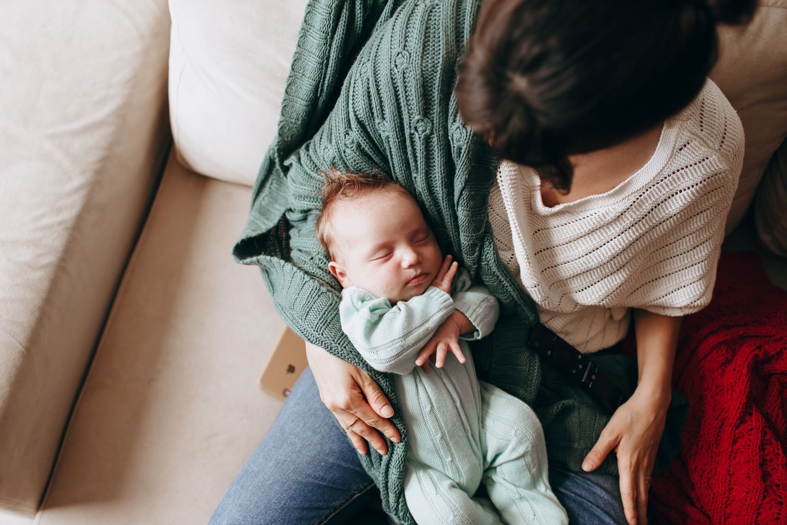 Eine Mutter hält ihr schlafendes Neugeborenes behutsam im Arm