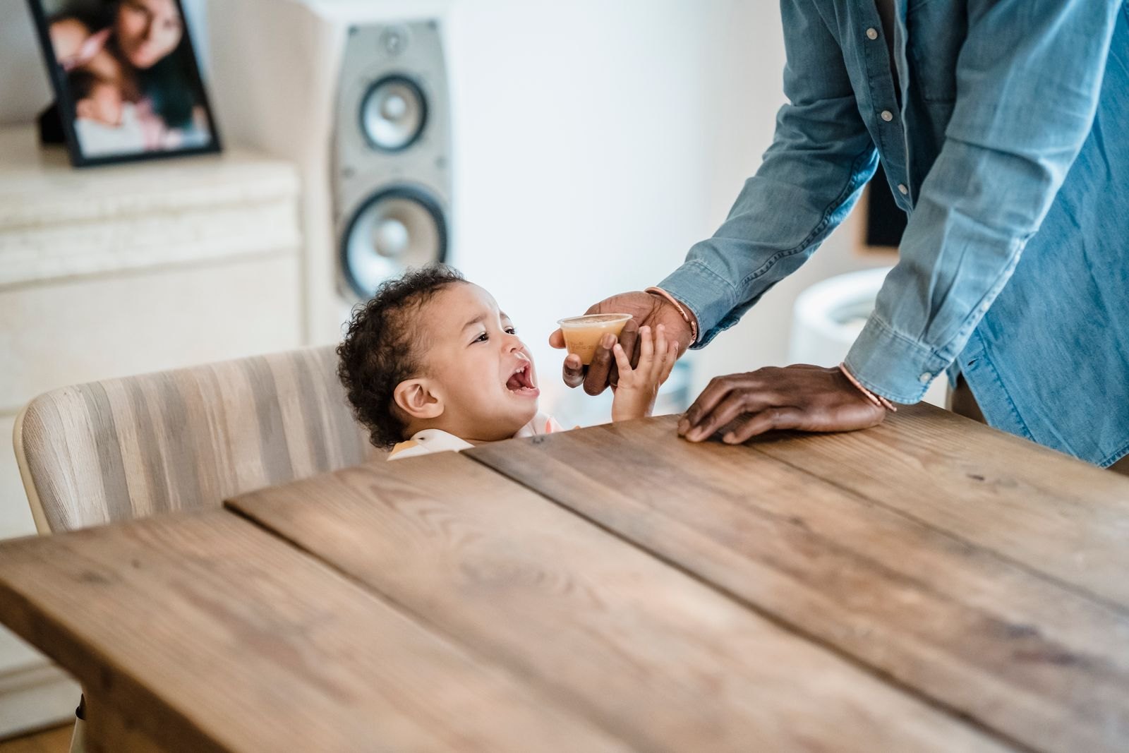 Weinendes Baby streckt die Hand nach einer Bezugsperson aus