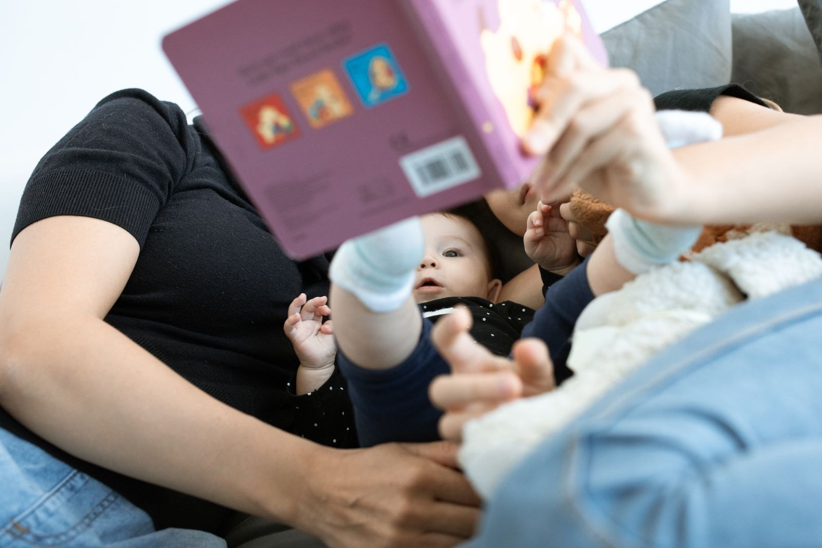 Nahaufnahme: Eltern lesen einem Baby aus einem Bilderbuch vor