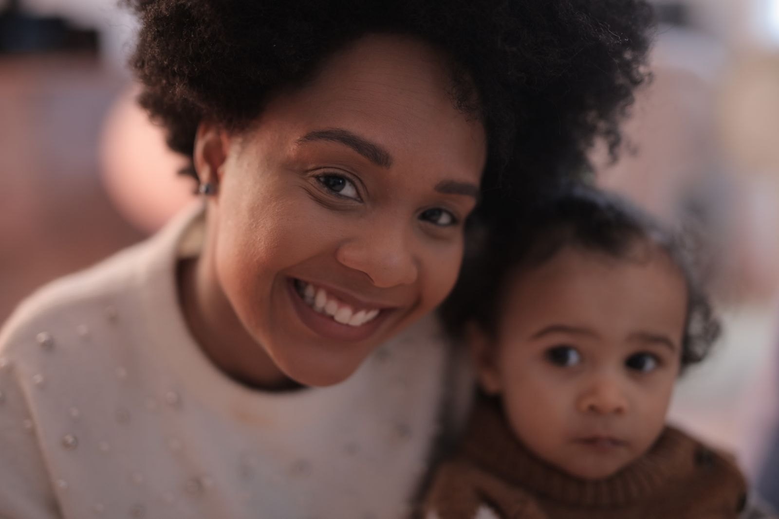 A parent and baby close together, making eye contact and smiling