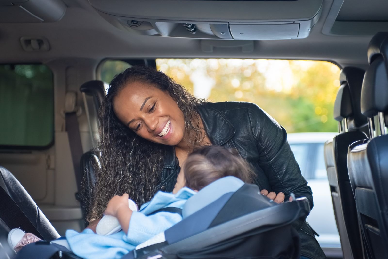 Close-up of a car seat chest clip positioned at armpit level on a child's harness straps