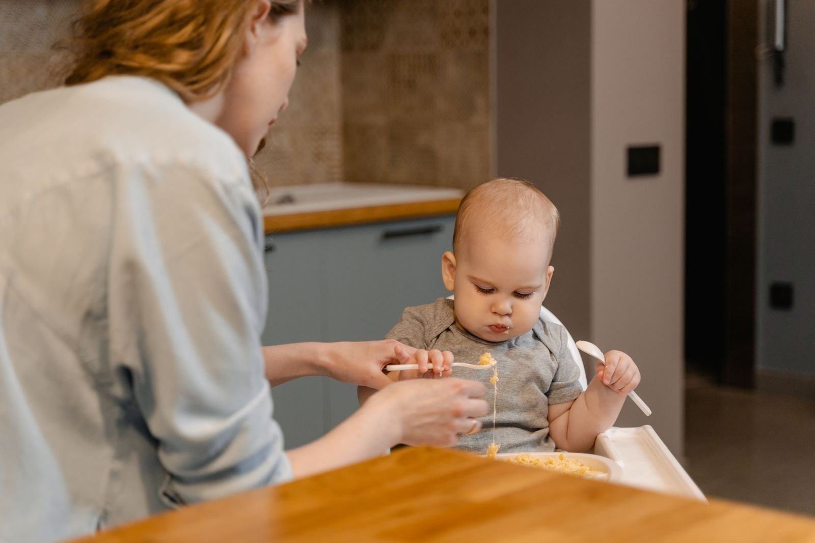 A baby in a high chair being introduced to solid foods