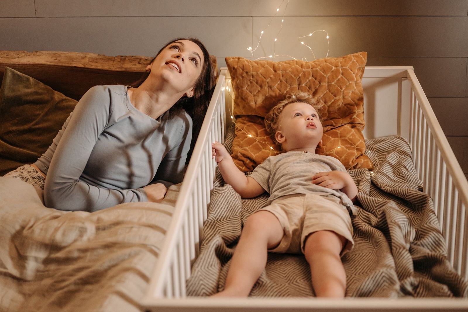 A parent lying down with a child during a calm bedtime routine