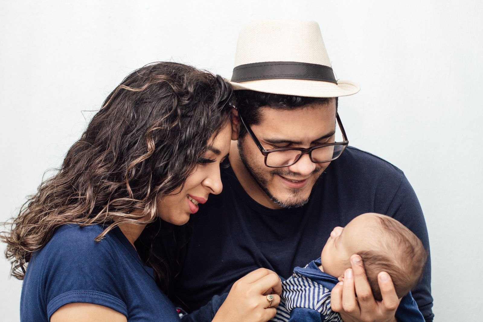 A couple smiling together while holding their baby