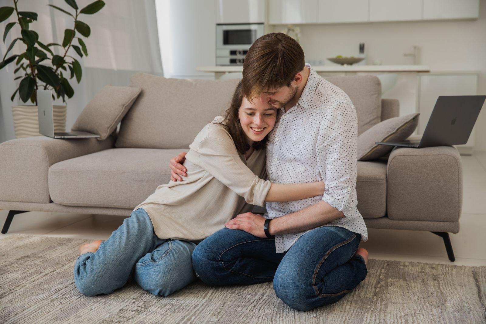 Una pareja se abraza en el salón de su casa después de resolver una discusión