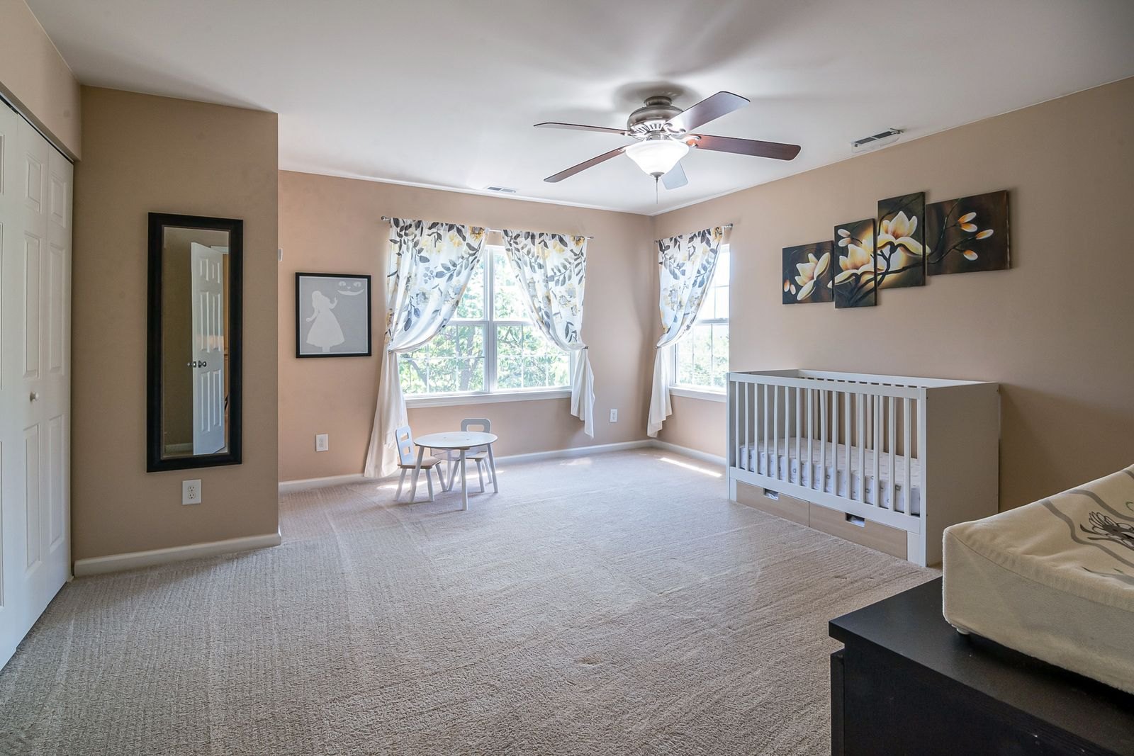 Habitación infantil decorada y lista, con una cuna propia, preparada para cuando el bebé haga la transición fuera del cuarto de los padres