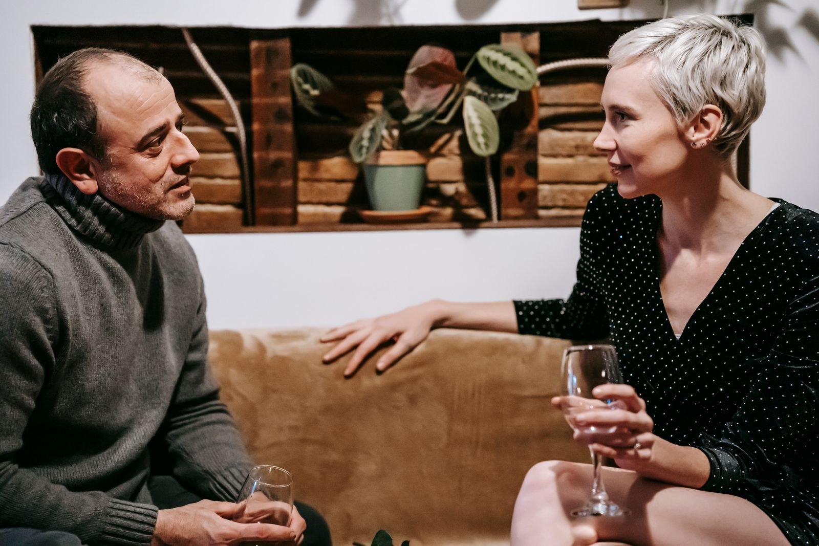 Una pareja conversa sentada muy cerca en el sofá, cercanos sin necesidad de más contacto físico