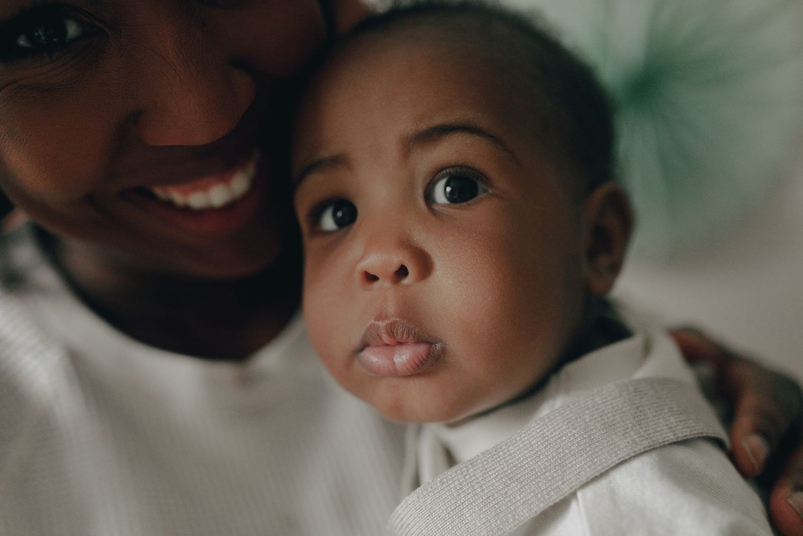 Un parent et son bébé tout proches l'un de l'autre, en train de rire en se regardant dans les yeux