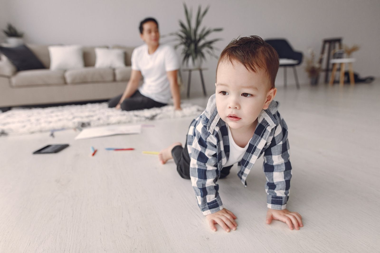 Bébé qui joue à quatre pattes sur le sol du salon, en toute liberté de mouvement