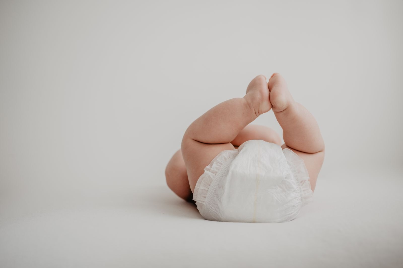 Un neonato con un pannolino pulito, i piedini sollevati