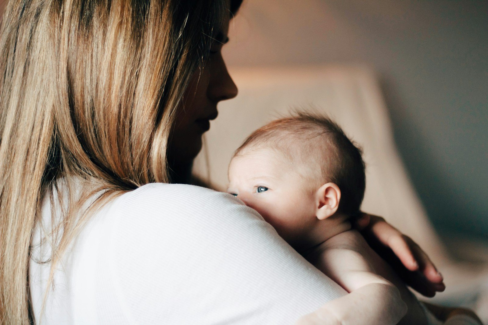 A parent calmly holding and soothing a crying newborn