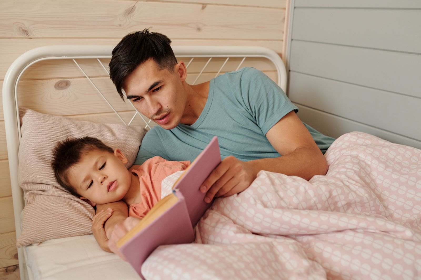 寝る前に絵本を読み聞かせる父親と子ども