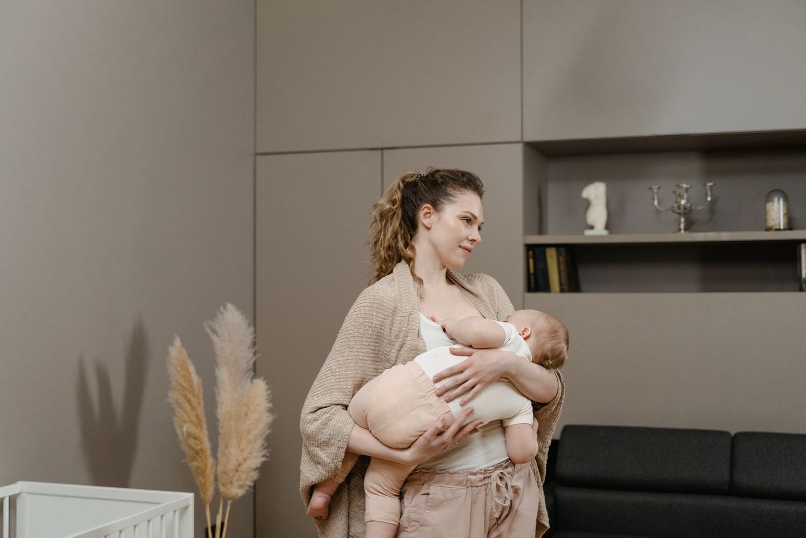 Een moeder houdt haar baby vast bij de wieg tijdens een rustig moment overdag
