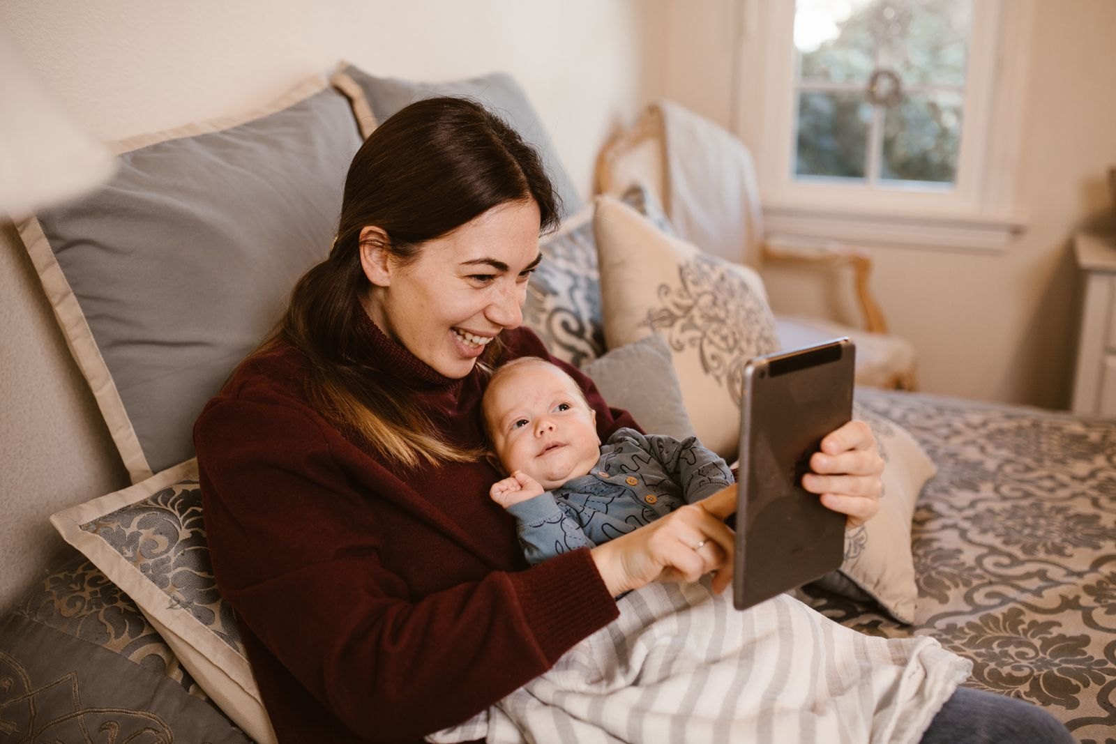 Een moeder videobelt samen met haar baby vanaf de bank