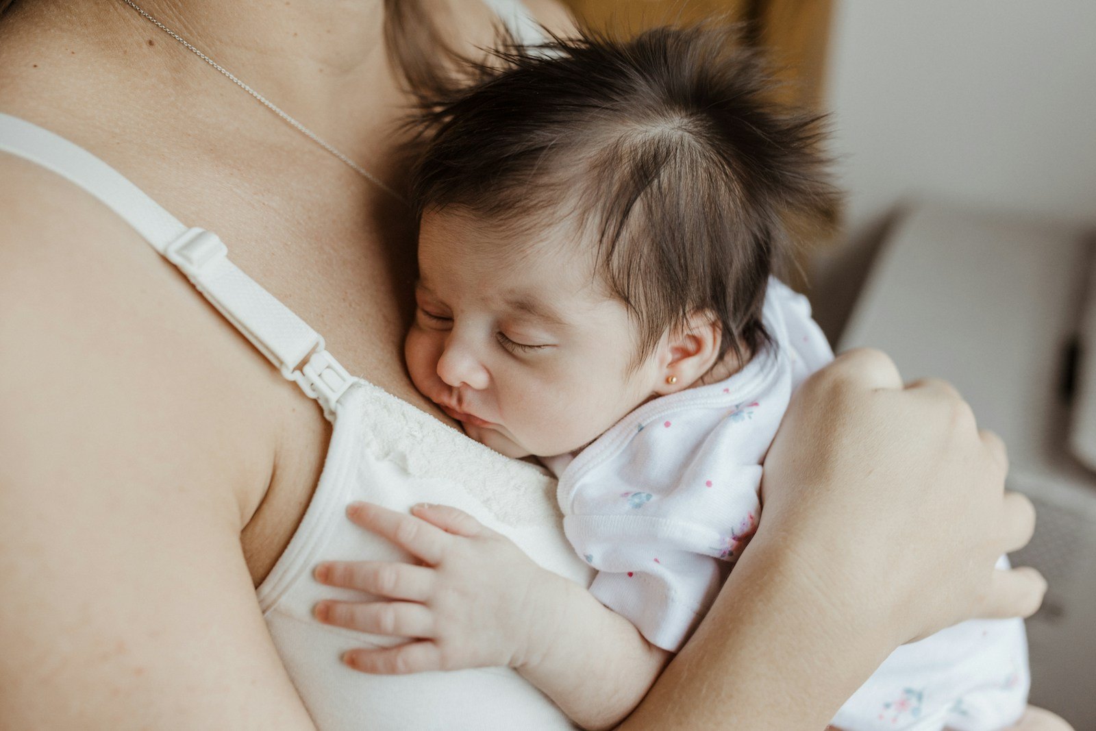 Een baby wordt na de voeding rechtop tegen de schouder gehouden
