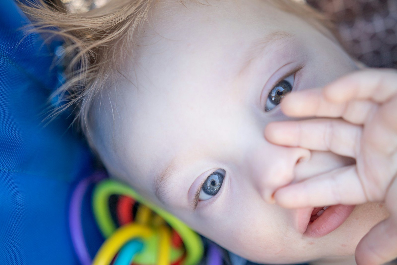 Een baby kauwt op een kleurrijke bijtring, een normaal onderdeel van het doorkomen van tandjes