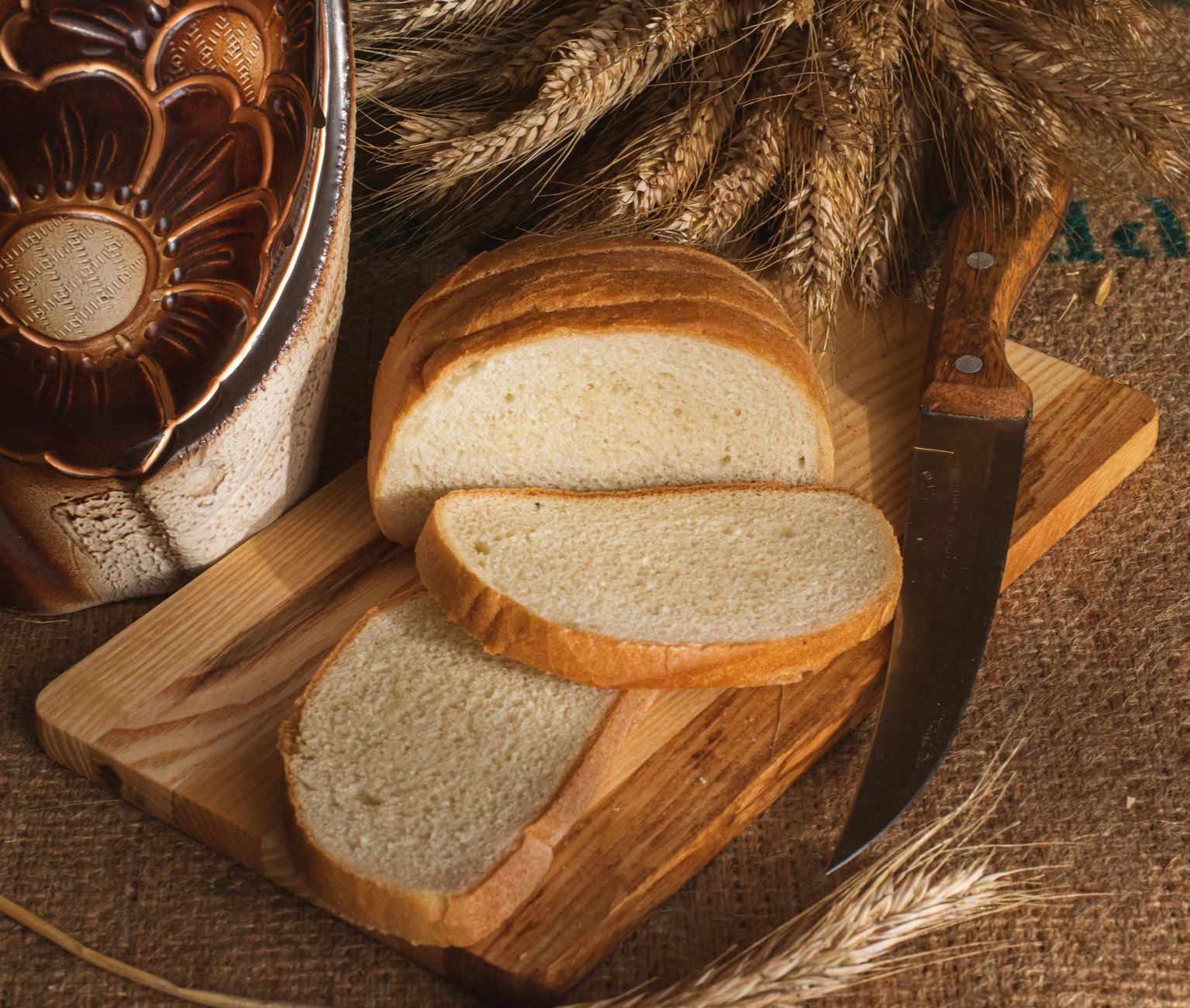 White bread on a board, an example of a low-fiber refined carbohydrate that is easy to overeat