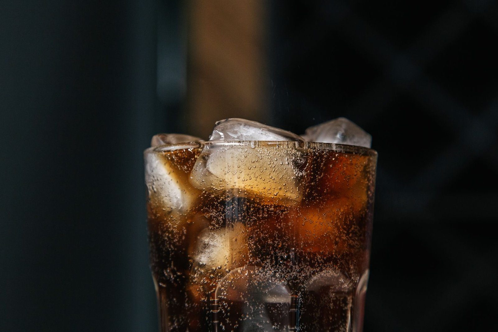 A glass of cola on a table, one of the everyday sugar-sweetened drinks that push blood triglycerides up