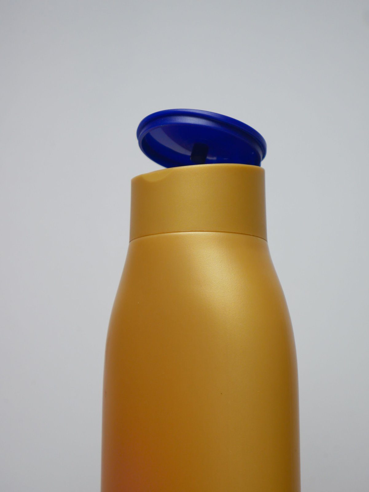 A shampoo bottle beside a scalp close-up, illustrating how washing technique relates to scalp odor