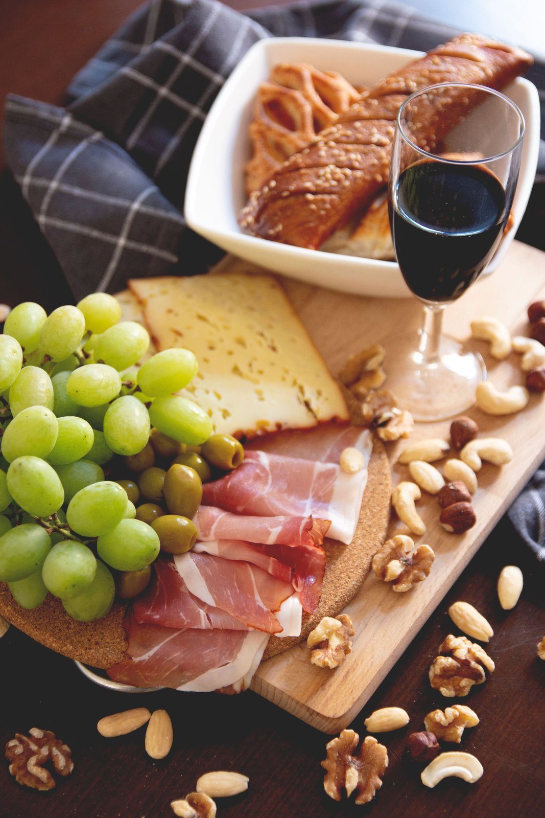 Un plateau de fromage affiné, de charcuterie et un verre de vin rouge, des aliments riches en histamine pouvant déclencher des symptômes nasaux