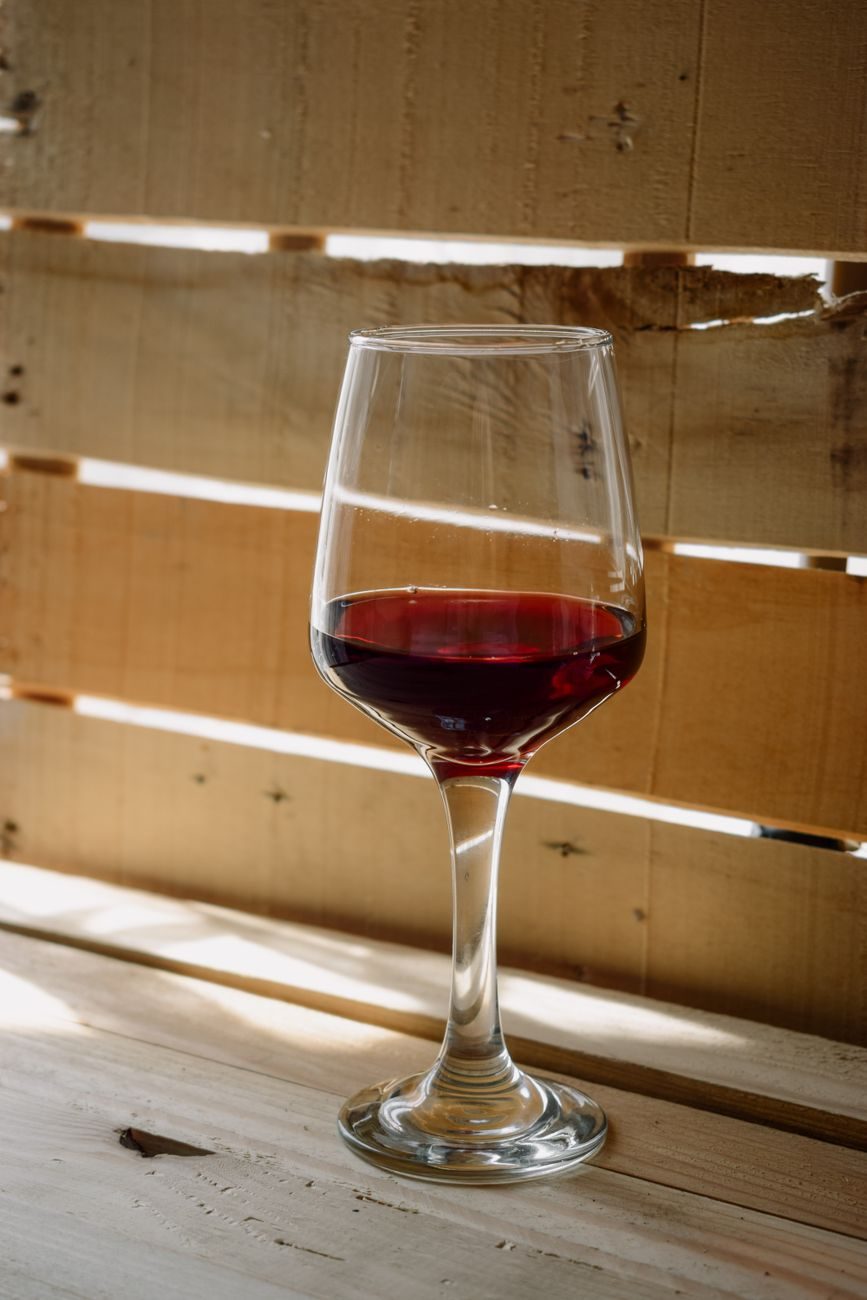 Calice di vino rosso accanto a una bottiglia