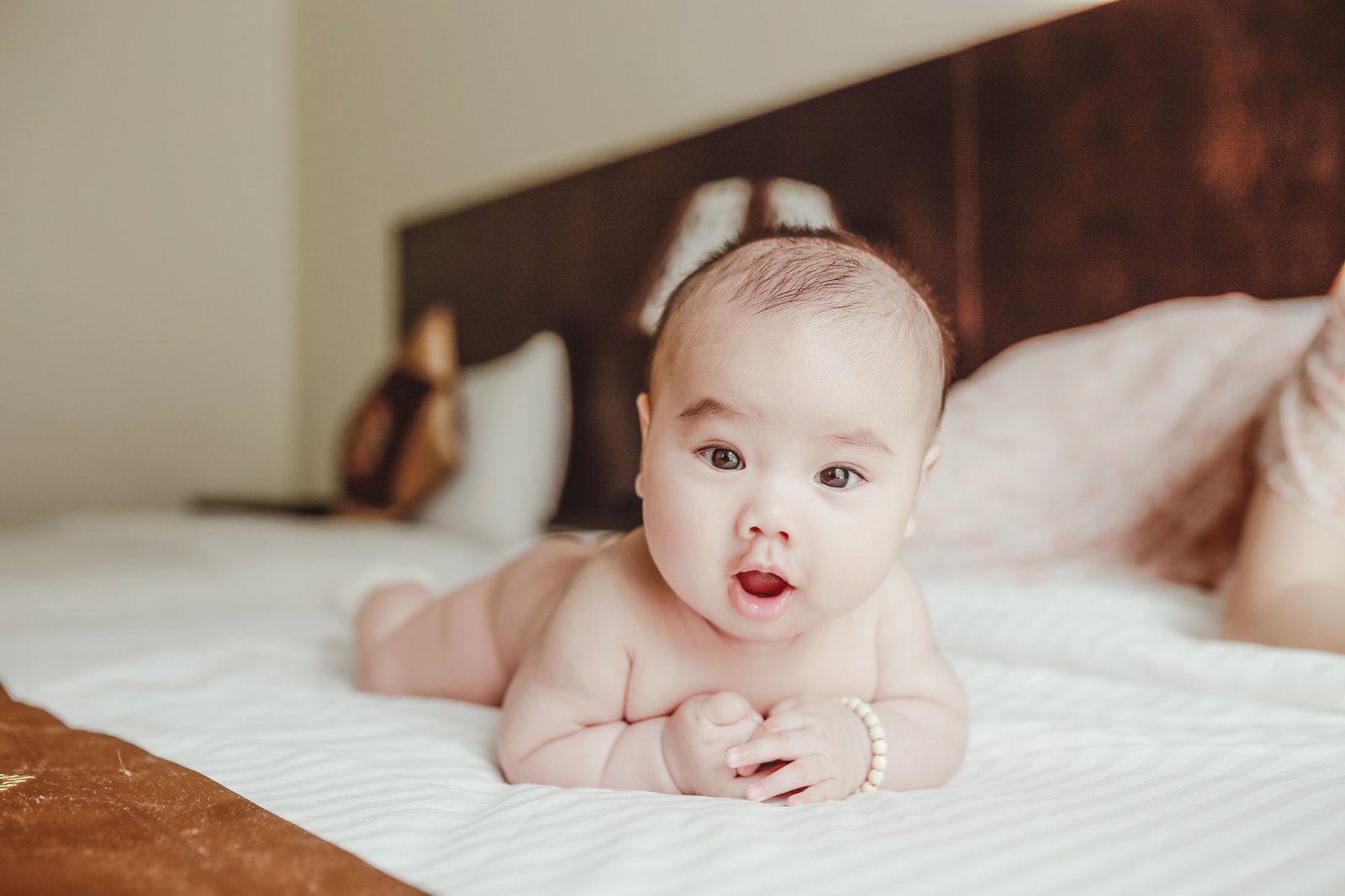 ベッドの上で目を丸くして起きている赤ちゃん