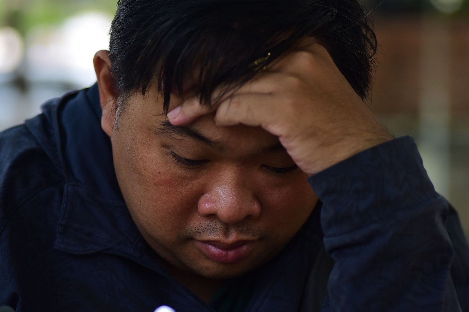 Iemand met de handen in het haar na een stressvolle periode, een bekende aanleiding voor tijdelijke haaruitval