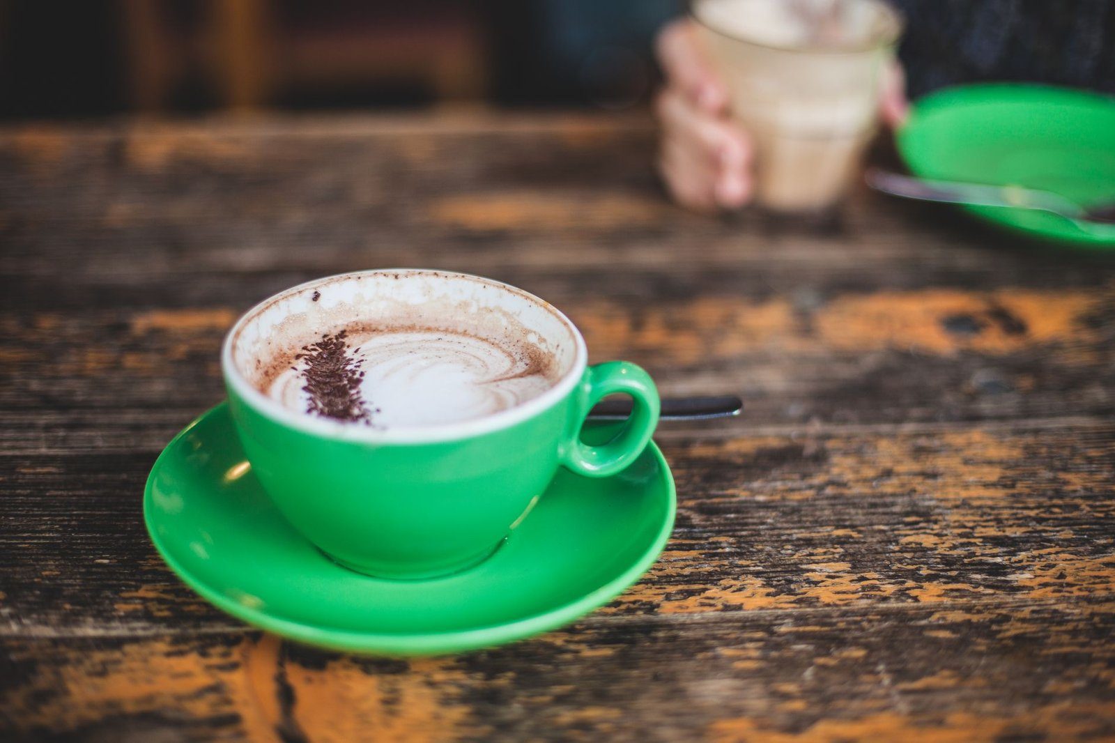 Kop koffie naast een maaltijd, waarvan de polyfenolen de ijzeropname remmen